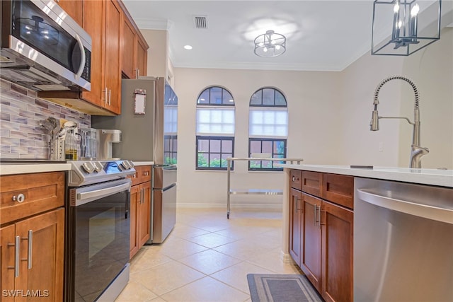 kitchen featuring tasteful backsplash, ornamental molding, stainless steel appliances, a notable chandelier, and light tile patterned flooring