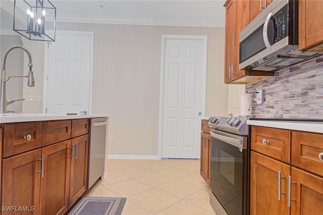 kitchen featuring tasteful backsplash, ornamental molding, pendant lighting, and appliances with stainless steel finishes