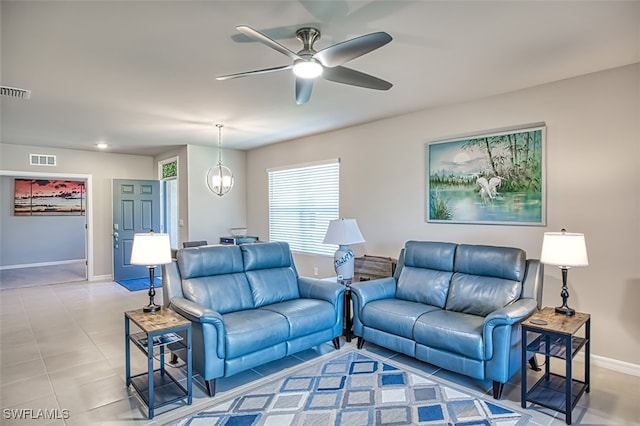 living room with light tile patterned flooring and ceiling fan with notable chandelier