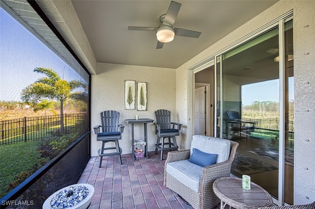 sunroom / solarium featuring ceiling fan