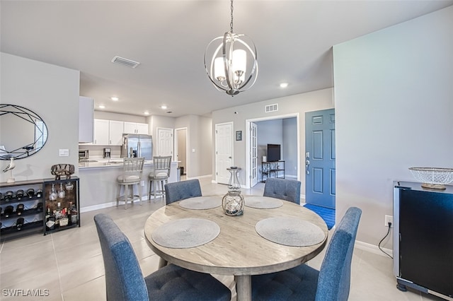 tiled dining area featuring a chandelier