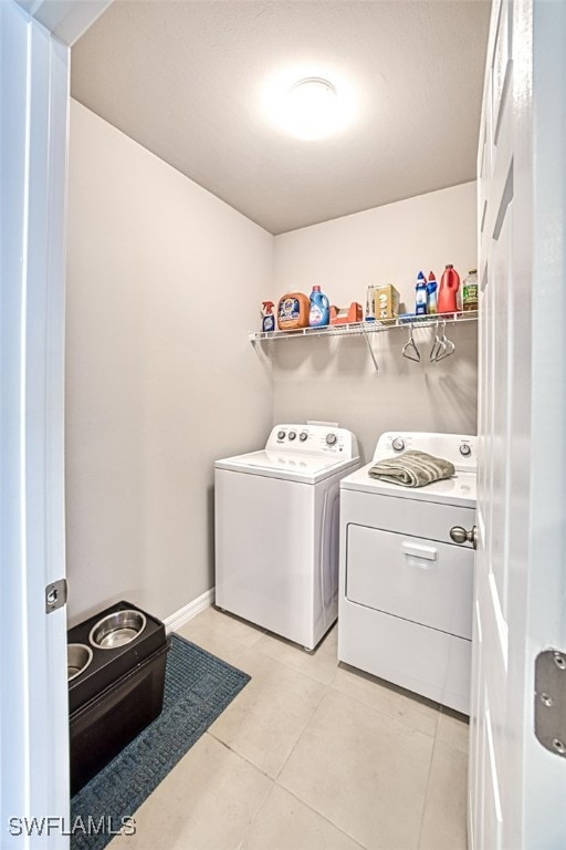 laundry room with light tile patterned flooring and separate washer and dryer