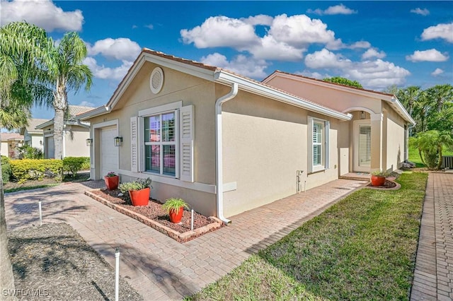 view of side of property featuring a yard and a garage