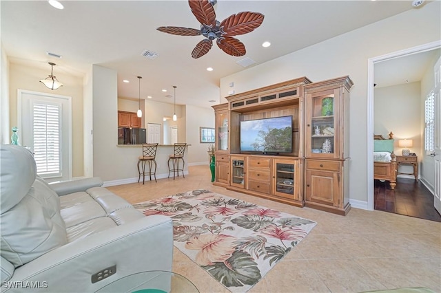 living room featuring light tile patterned floors and ceiling fan