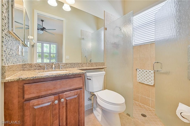 bathroom featuring ceiling fan, tile patterned flooring, toilet, vanity, and a shower with shower door