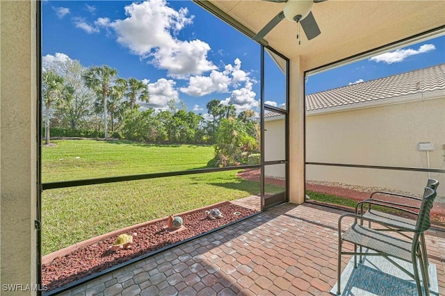 unfurnished sunroom featuring ceiling fan