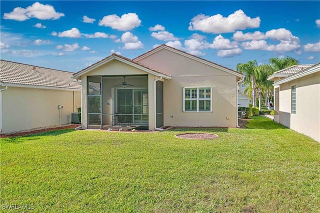 back of property with central AC unit, a lawn, and a sunroom