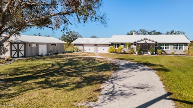 single story home with an outbuilding, a front lawn, and a garage