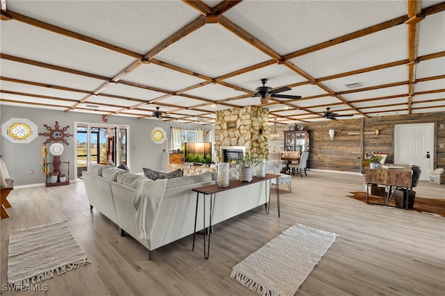 living room with a textured ceiling, a fireplace, hardwood / wood-style floors, and coffered ceiling