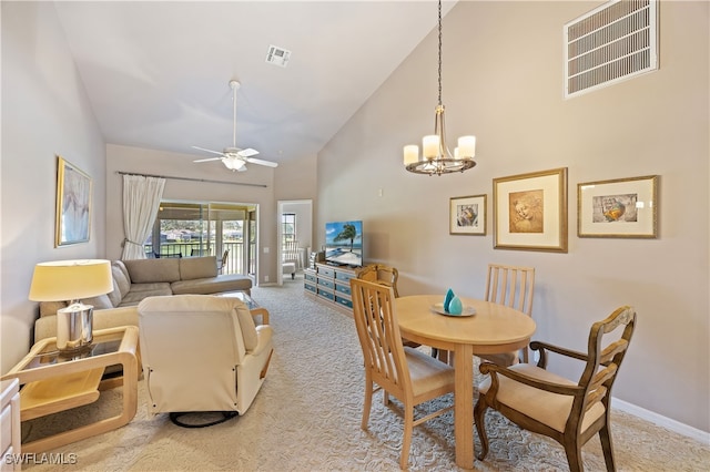 dining area with light carpet, high vaulted ceiling, and ceiling fan with notable chandelier