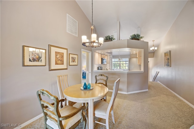 dining area featuring light colored carpet, high vaulted ceiling, and an inviting chandelier