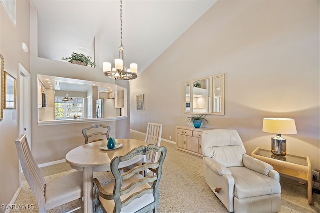 carpeted dining area featuring high vaulted ceiling and a chandelier