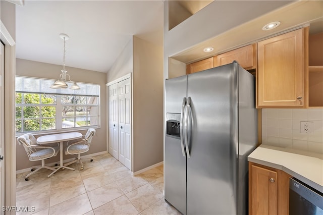 kitchen featuring black dishwasher, stainless steel fridge, vaulted ceiling, decorative light fixtures, and decorative backsplash