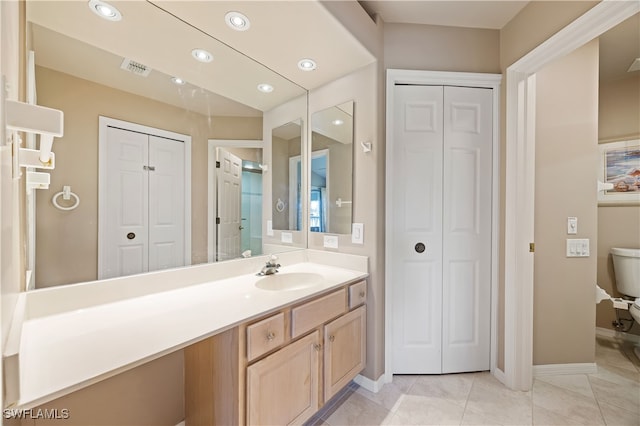 bathroom featuring tile patterned flooring, vanity, and toilet