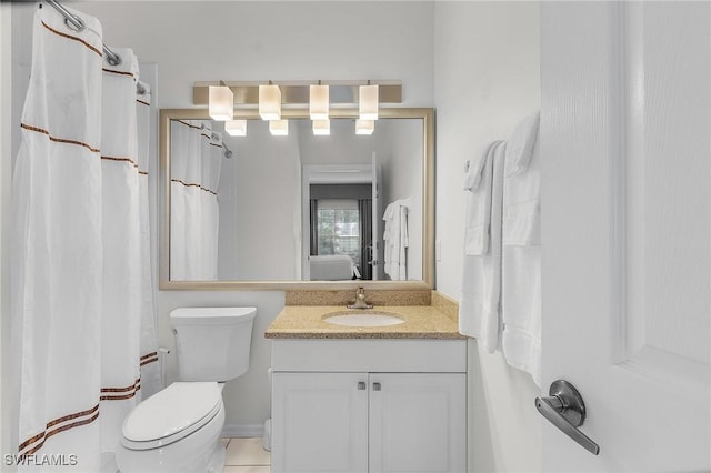 bathroom with tile patterned flooring, vanity, and toilet