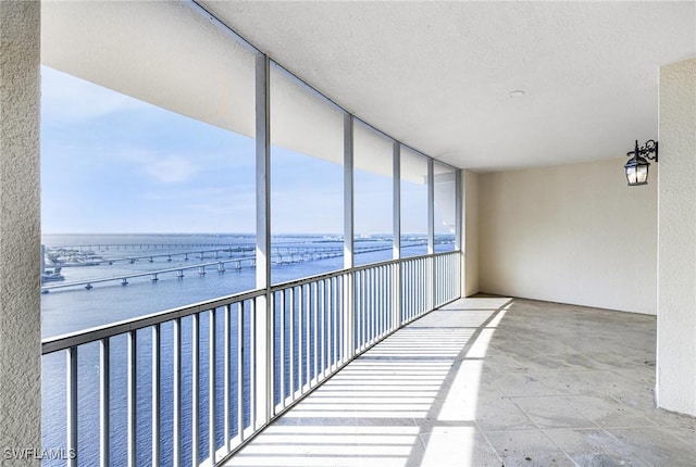 unfurnished sunroom featuring a water view