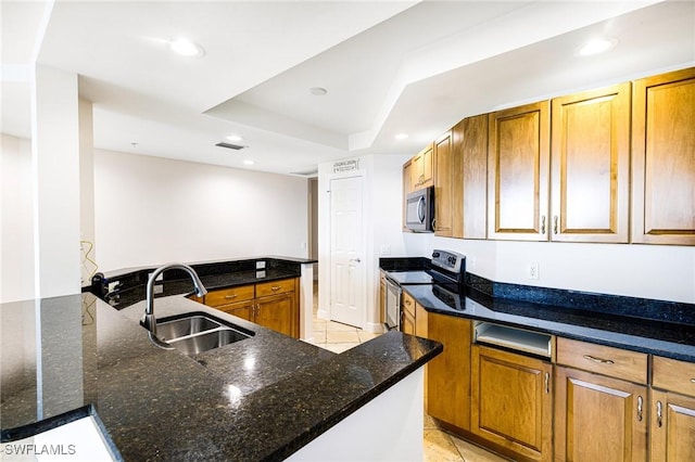 kitchen with sink, light tile patterned floors, electric range, dark stone countertops, and a center island