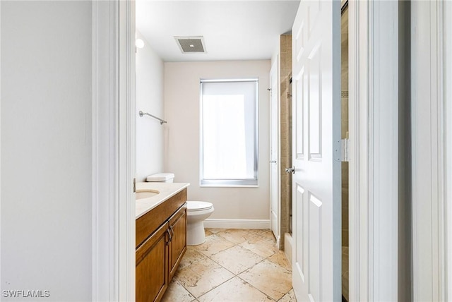 bathroom featuring vanity, toilet, and walk in shower