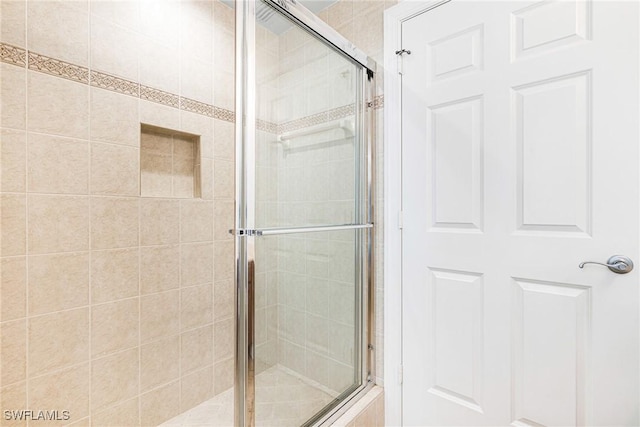 bathroom featuring a shower with door