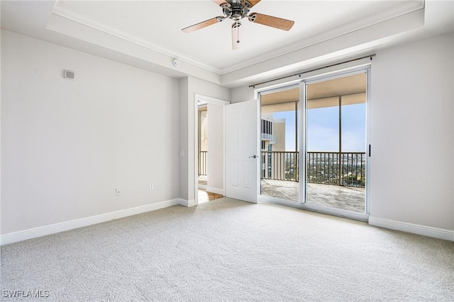 carpeted spare room featuring ceiling fan, a raised ceiling, and crown molding