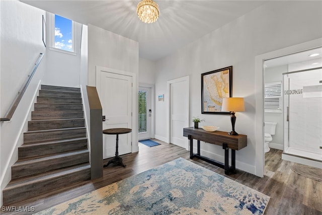 foyer entrance with hardwood / wood-style floors and an inviting chandelier