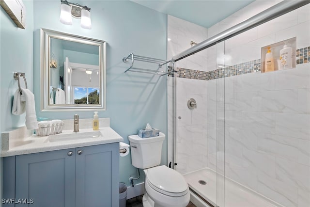 bathroom with vanity, toilet, and a shower with shower door