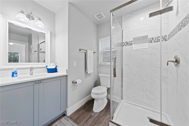 bathroom with vanity, hardwood / wood-style flooring, toilet, and a shower with shower door