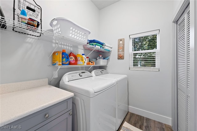 laundry area with independent washer and dryer and dark wood-type flooring