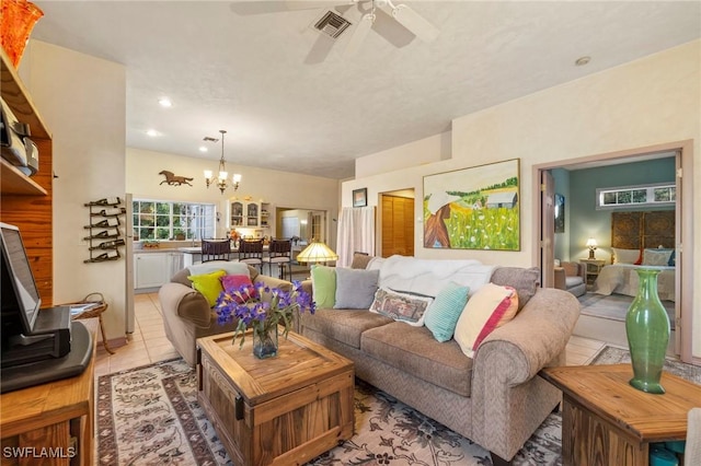 tiled living room featuring ceiling fan with notable chandelier