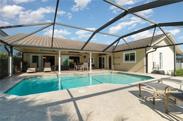 view of pool with ceiling fan, a patio, and glass enclosure