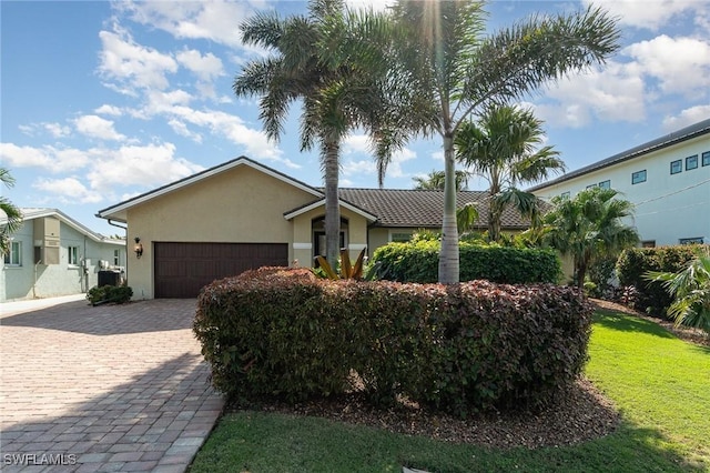 ranch-style home with a garage and a front lawn