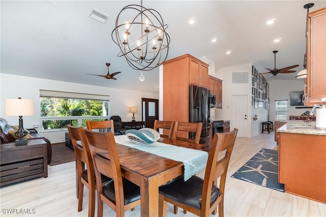 dining room featuring ceiling fan with notable chandelier, lofted ceiling, and sink