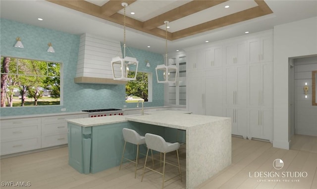 kitchen with decorative backsplash, a kitchen breakfast bar, a center island, and white cabinetry