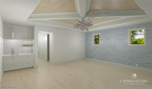 empty room with a tray ceiling and light hardwood / wood-style floors