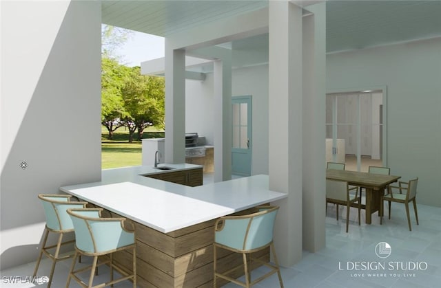 interior space featuring a kitchen bar, kitchen peninsula, sink, and light tile patterned floors