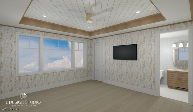 unfurnished room featuring hardwood / wood-style floors, a tray ceiling, ceiling fan, and sink