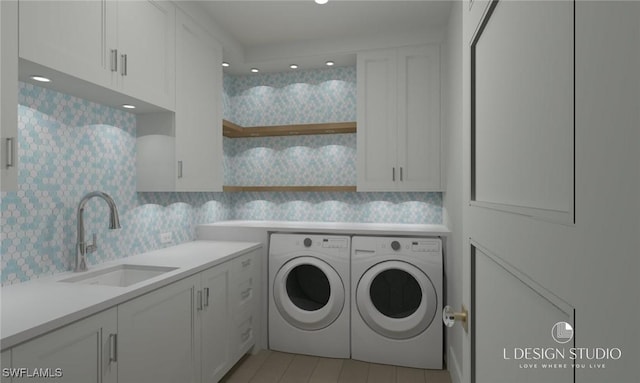 laundry room with washer and clothes dryer, cabinets, and sink