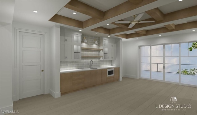 kitchen featuring decorative backsplash, white cabinetry, sink, and white microwave