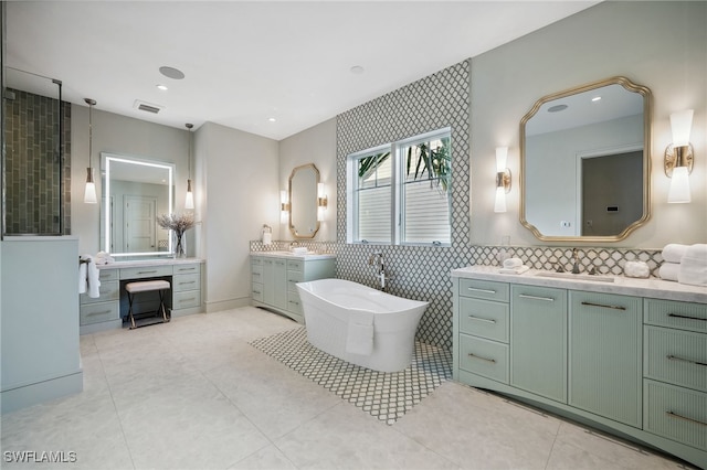 187 10th Ave S, Naples, FL 34102 - full bathroom featuring two vanities, a freestanding bath, tile patterned floors, tile walls, and recessed lighting