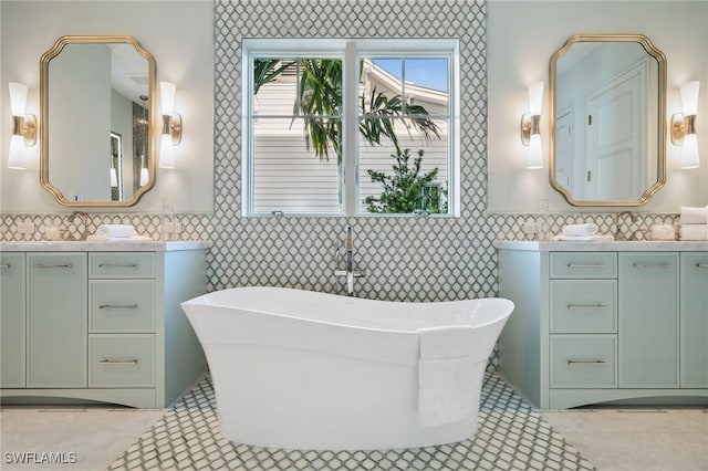 187 10th Ave S, Naples, FL 34102 - bathroom featuring two vanities, a freestanding bath, and tile patterned floors