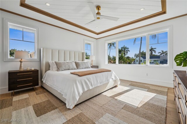 187 10th Ave S, Naples, FL 34102 - bedroom with crown molding, baseboards, light wood finished floors, ceiling fan, and a tray ceiling