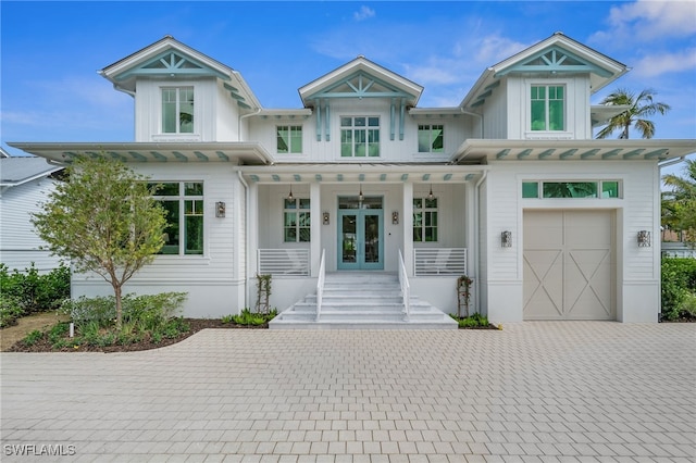 187 10th Ave S, Naples, FL 34102 - view of front of house with french doors, board and batten siding, a porch, decorative driveway, and a garage