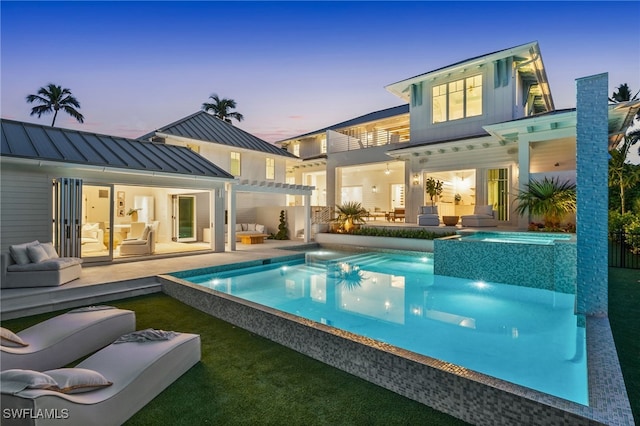 187 10th Ave S, Naples, FL 34102 - rear view of property with an outdoor living space, a standing seam roof, a pool with connected hot tub, and metal roof