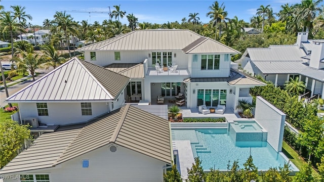 187 10th Ave S, Naples, FL 34102 - rear view of house featuring a standing seam roof, a balcony, metal roof, a patio, and a pool with connected hot tub
