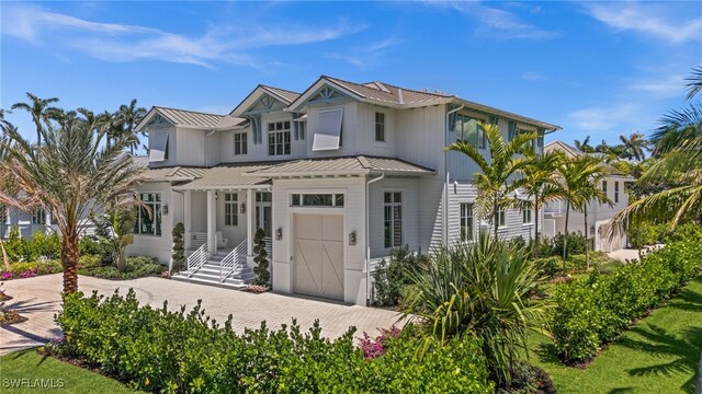 187 10th Ave S, Naples, FL 34102 - view of front of property featuring a standing seam roof, decorative driveway, metal roof, board and batten siding, and an attached garage