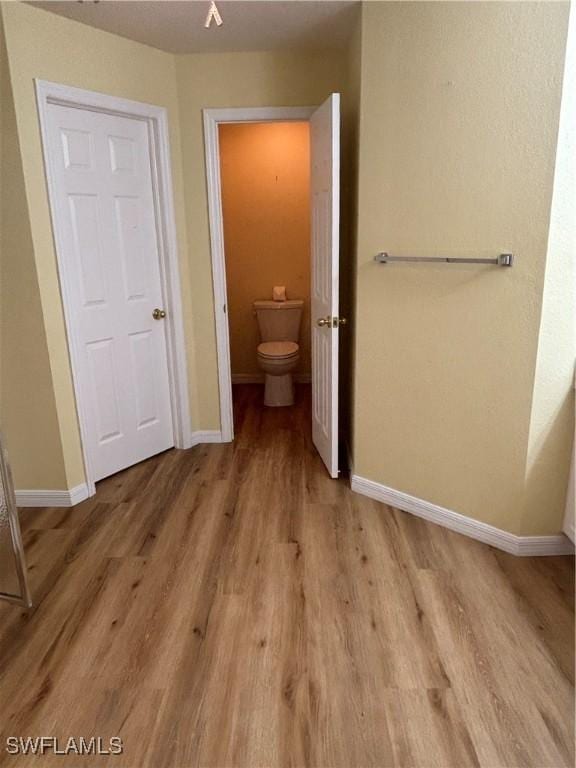 unfurnished bedroom featuring connected bathroom and light hardwood / wood-style flooring