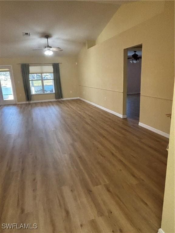 unfurnished room featuring hardwood / wood-style flooring, vaulted ceiling, and a healthy amount of sunlight