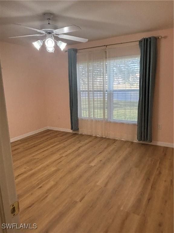 spare room with ceiling fan and light wood-type flooring