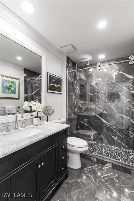 full bathroom featuring toilet, marble finish floor, a marble finish shower, and crown molding