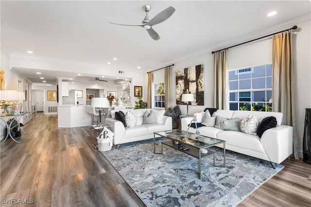 living room featuring a ceiling fan, crown molding, and wood finished floors